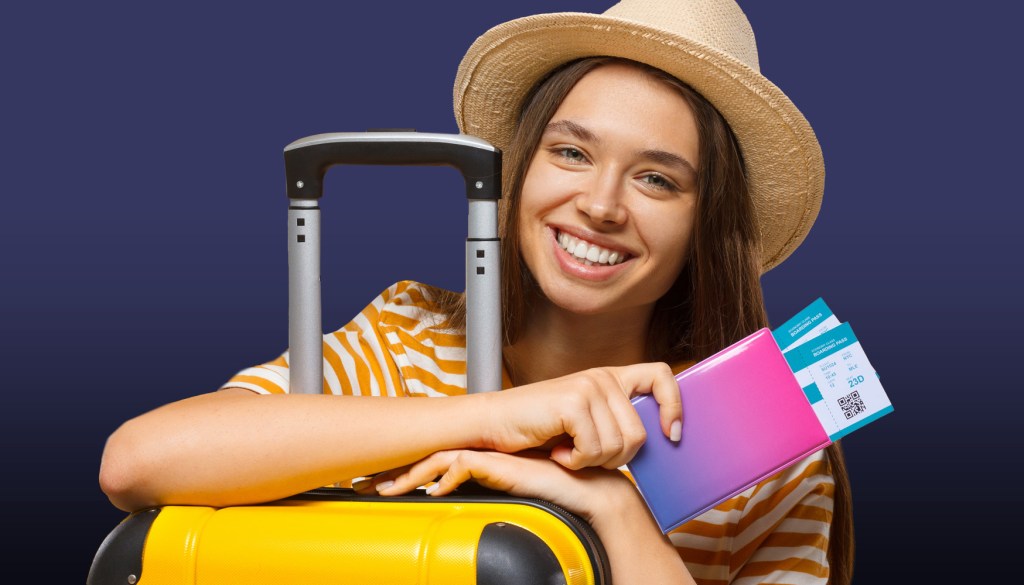Femme joyeuse dans une ambiance de vacances avec un chapeau, une valise et des billets d'avion à la main, prête à voyager.