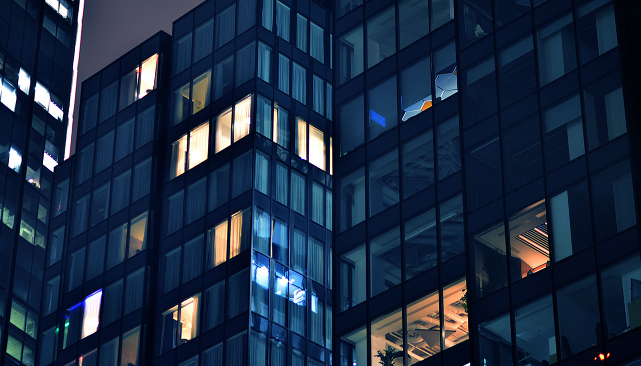 Nachhaltiges Workforce Management im Bürogebäude mit leuchtenden Fenstern