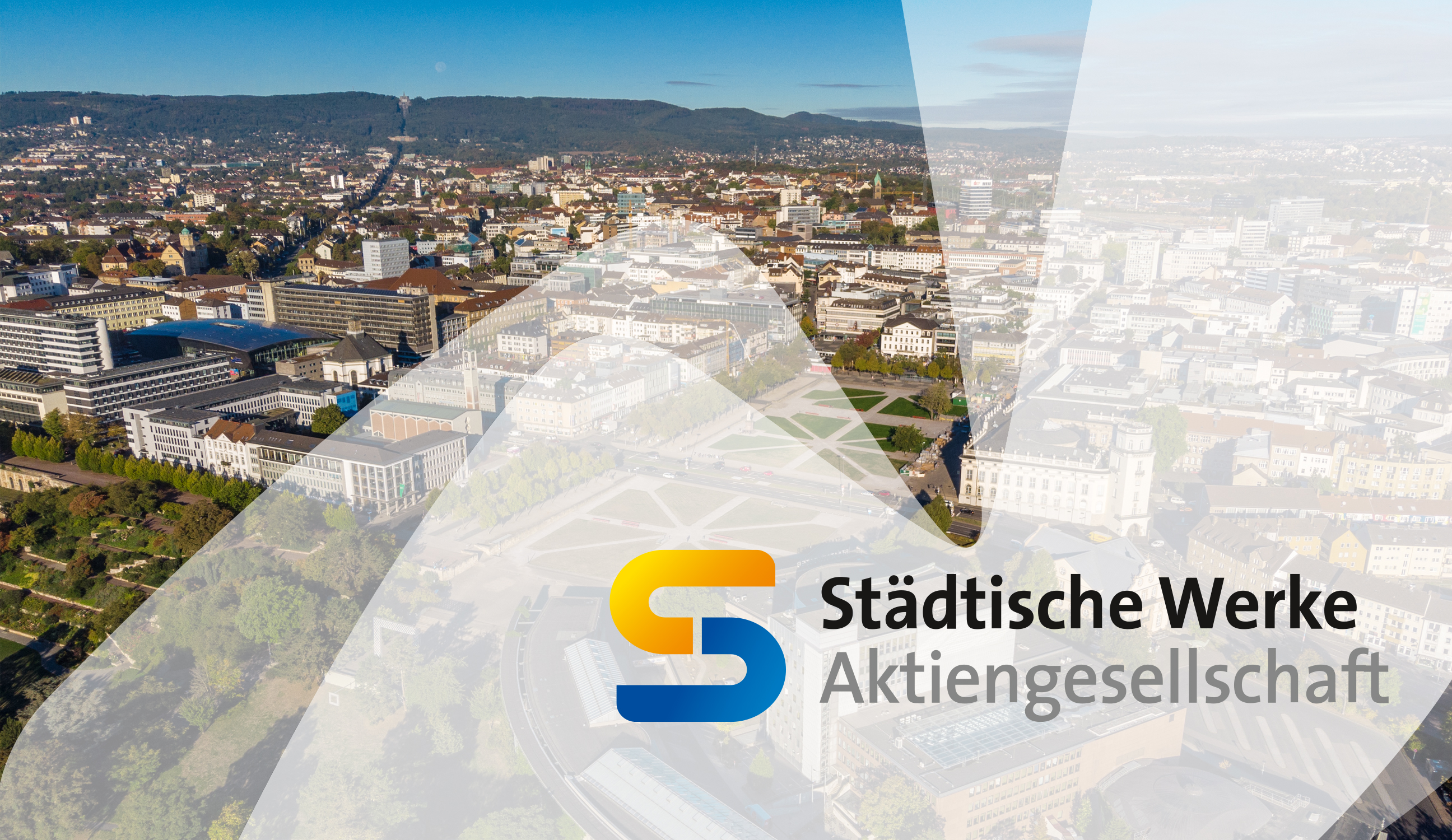 Luftaufnahme einer Stadt mit zahlreichen Gebäuden, Straßen und Grünflächen. Im Vordergrund befindet sich ein halbtransparenter Bereich mit dem Logo der Städtische Werke Aktiengesellschaft, bestehend aus einem stilisierten, gelb-blauem Buchstaben S und dem Schriftzug 'Städtische Werke Aktiengesellschaft' in schwarzer und grauer Schrift.