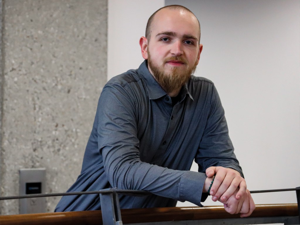 Mann an Geländer lehnend, Noah Kellner als Referenz für Dienstplanung bei plano