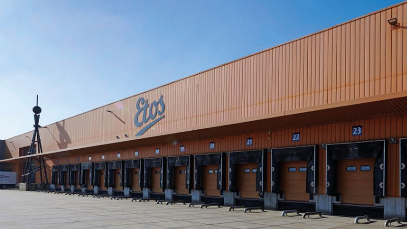 Etos Distribution Center – exterior view of the warehouse with a truck on the left side and the Etos logo on the building facade. Customer reference for plano.