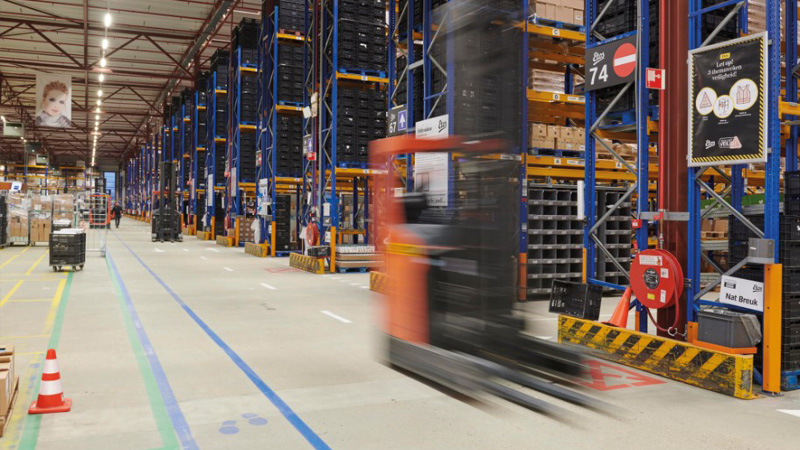 Internal view of a warehouse at the Etos distribution center. In the foreground, there is a forklift.